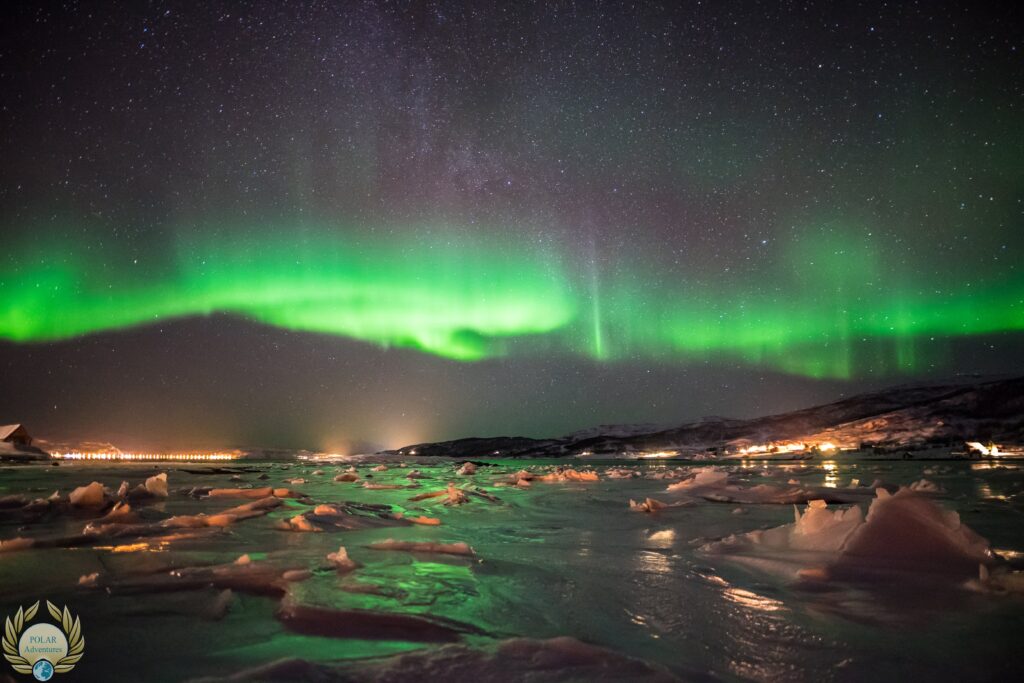 Aurora boreale verde sopra lago ghiacciato