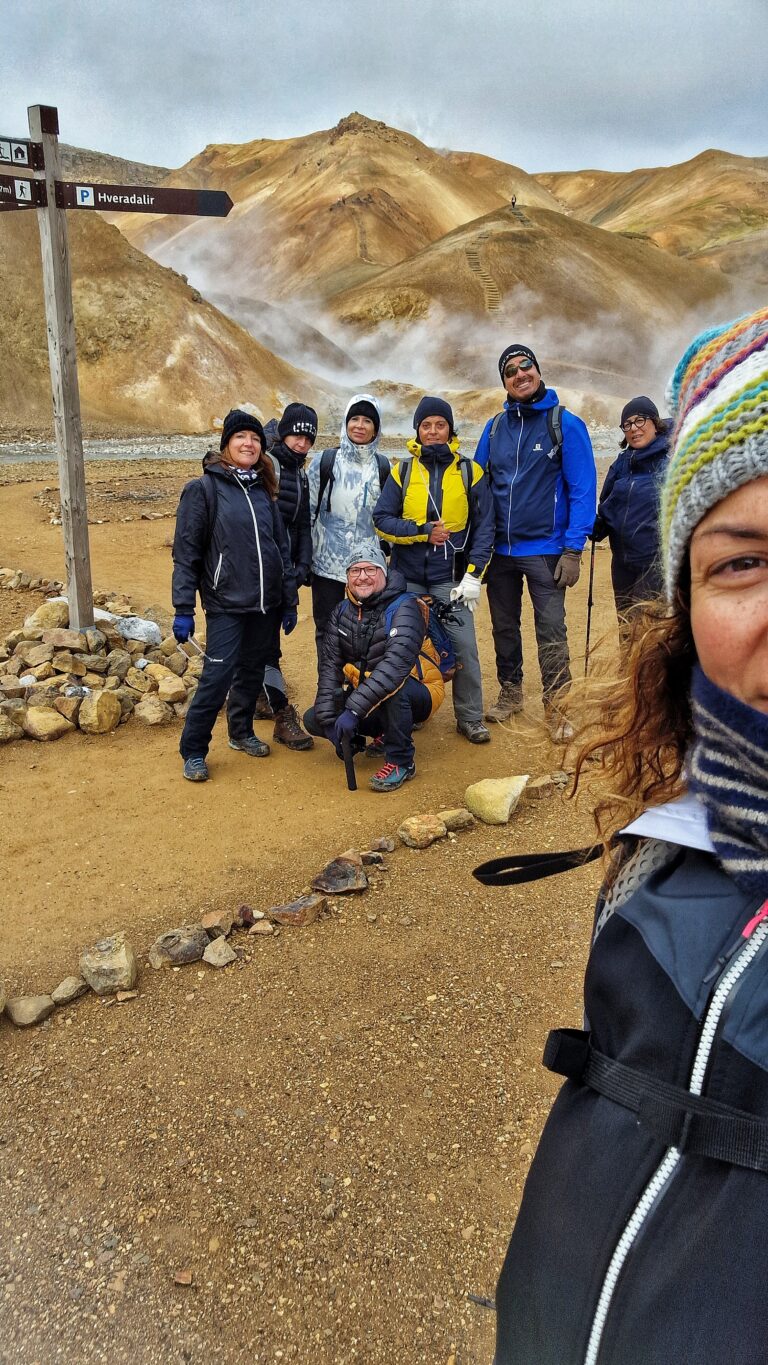 Persone su terreno rossastro e fumarole