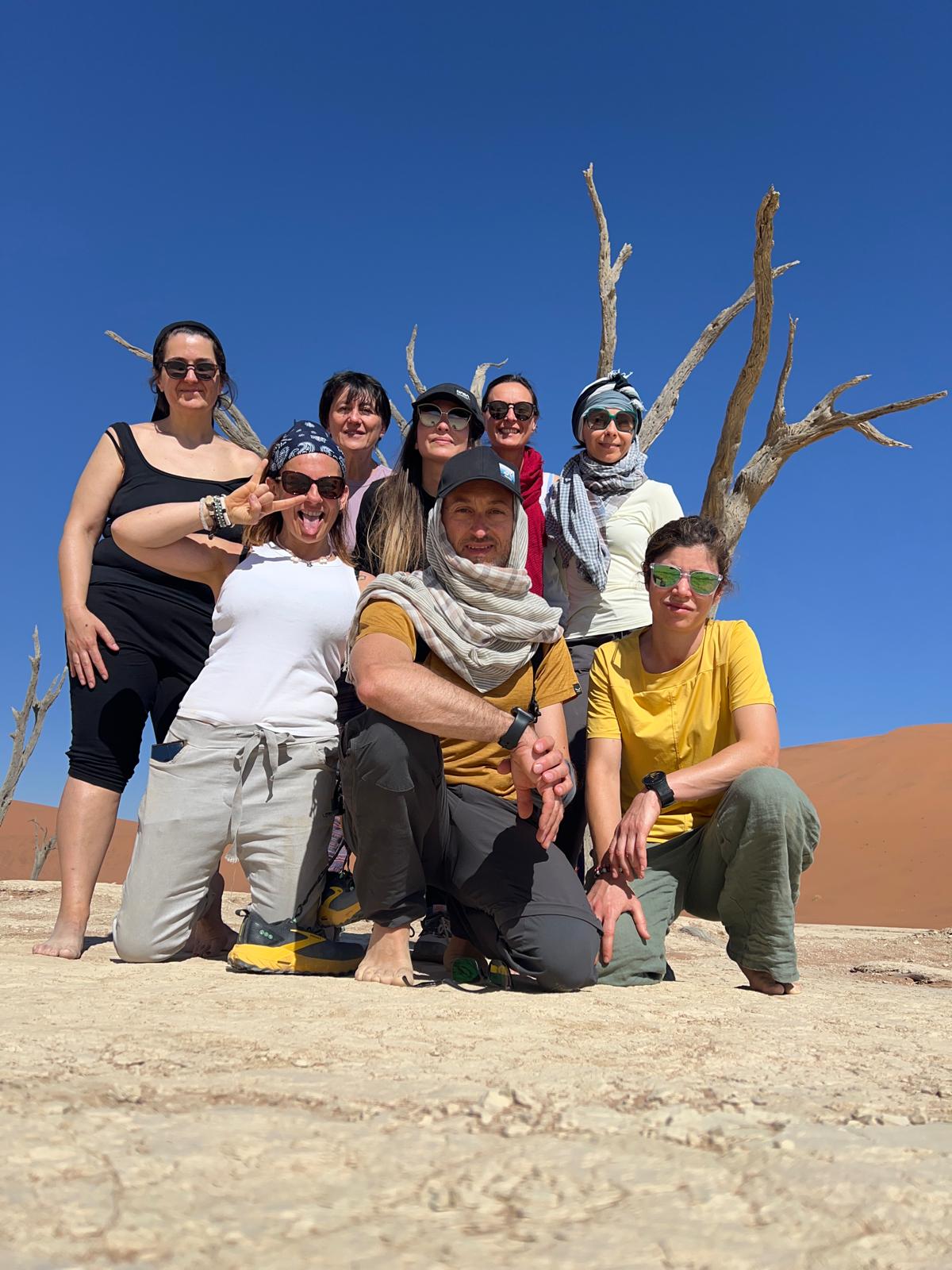 Persone in posa su terreno desertico con cielo blu