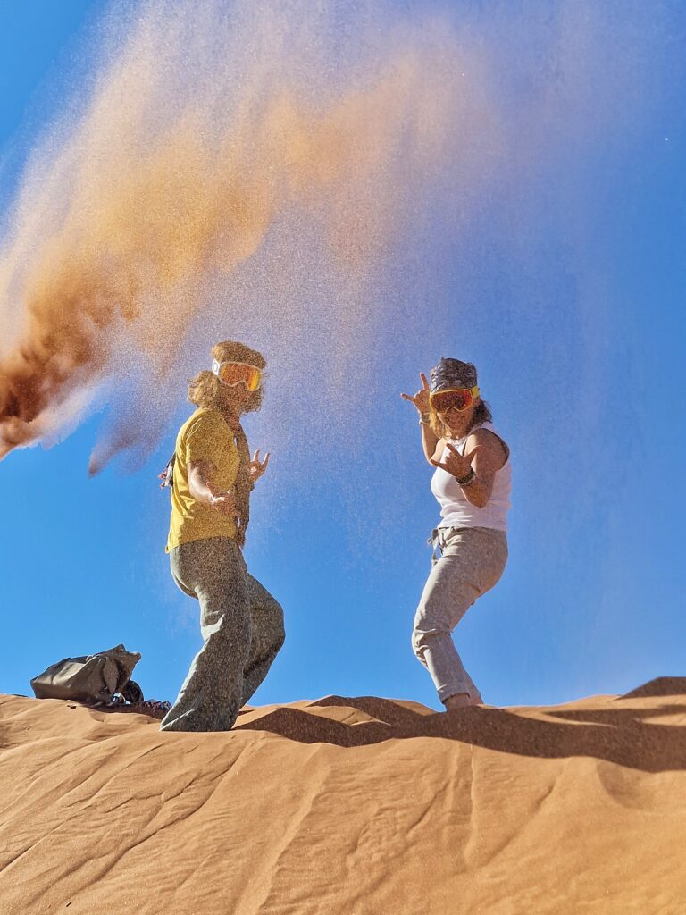 Due persone sulla cresta di una duna del deserto