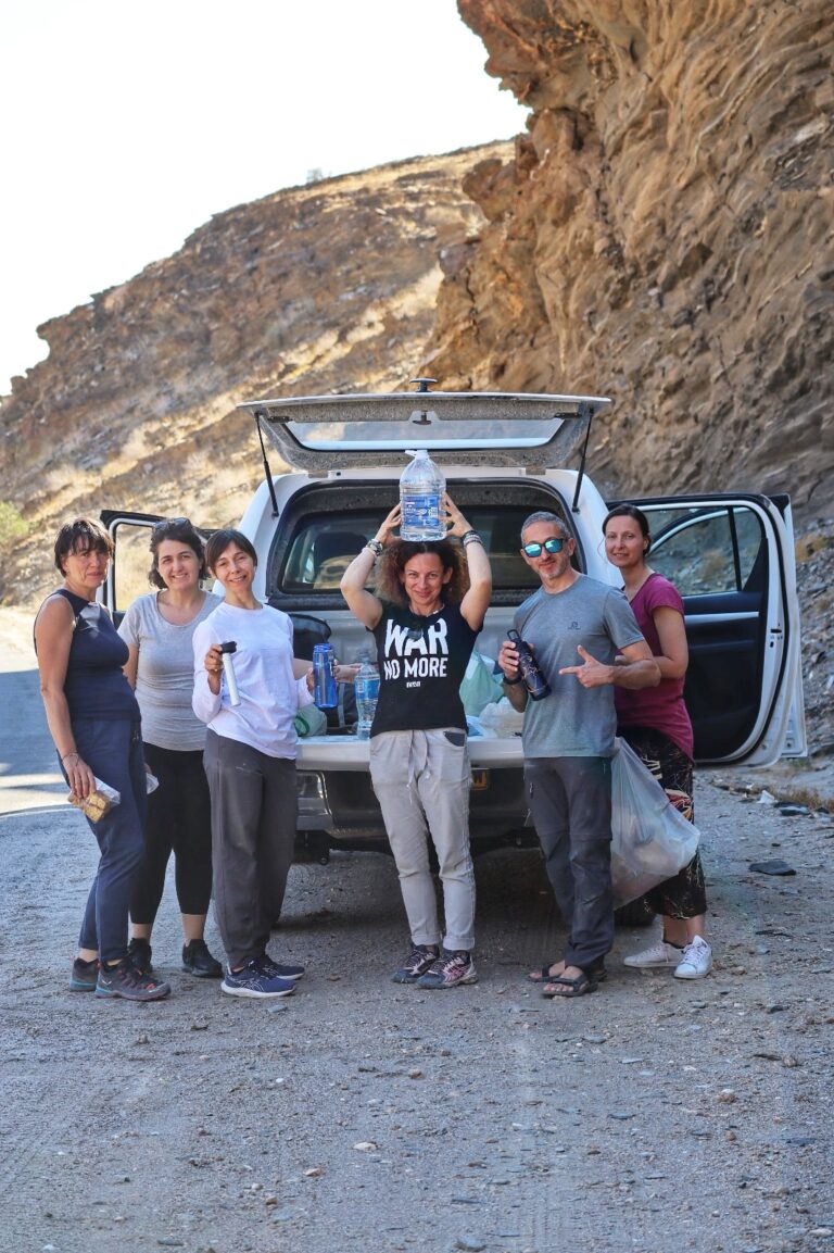 Gruppo di persone davanti ad una jeep ai piedi di una montagna